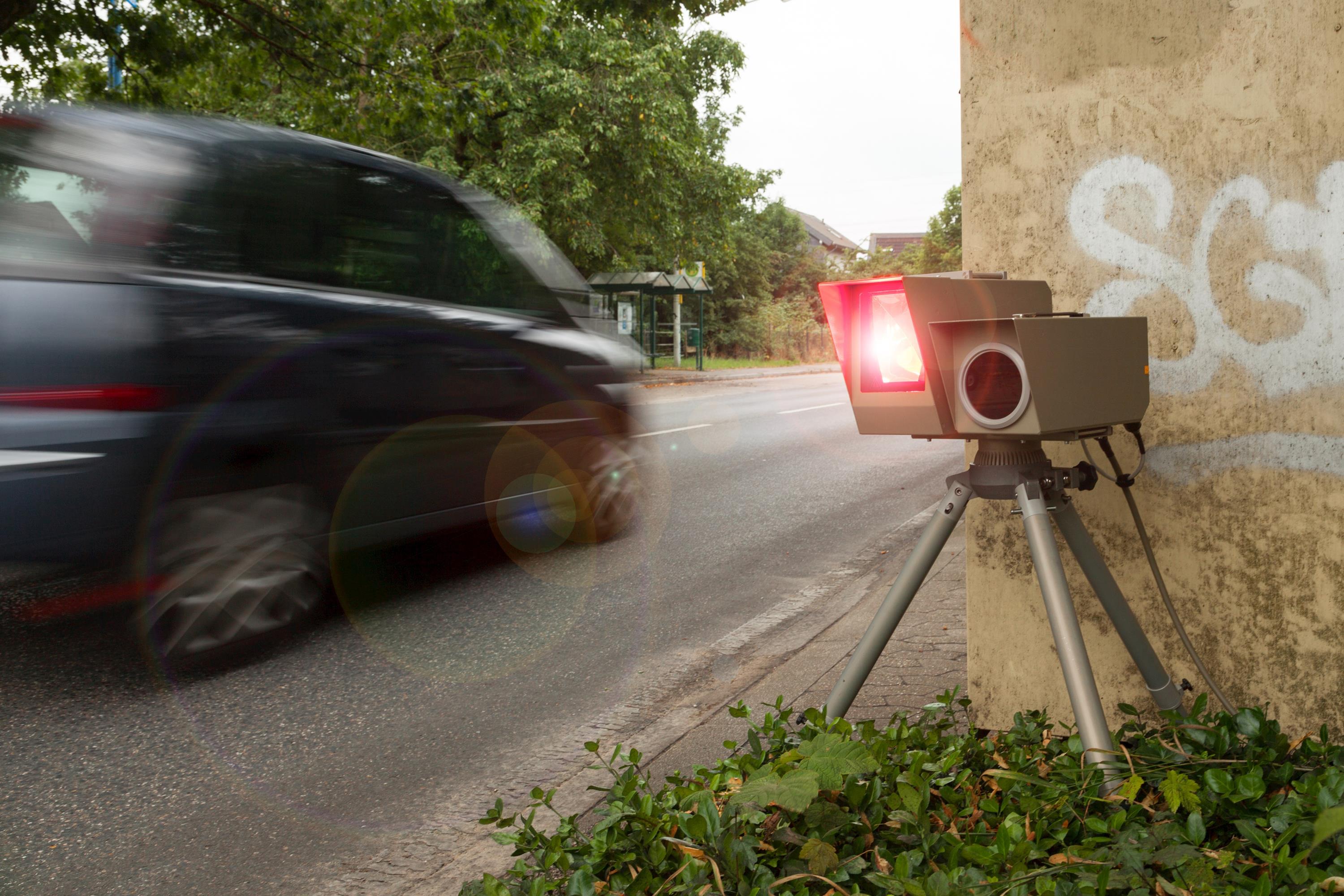 Eine auslösende Geschwindigkeitsmessanlage mit vorbeifahrendem Auto