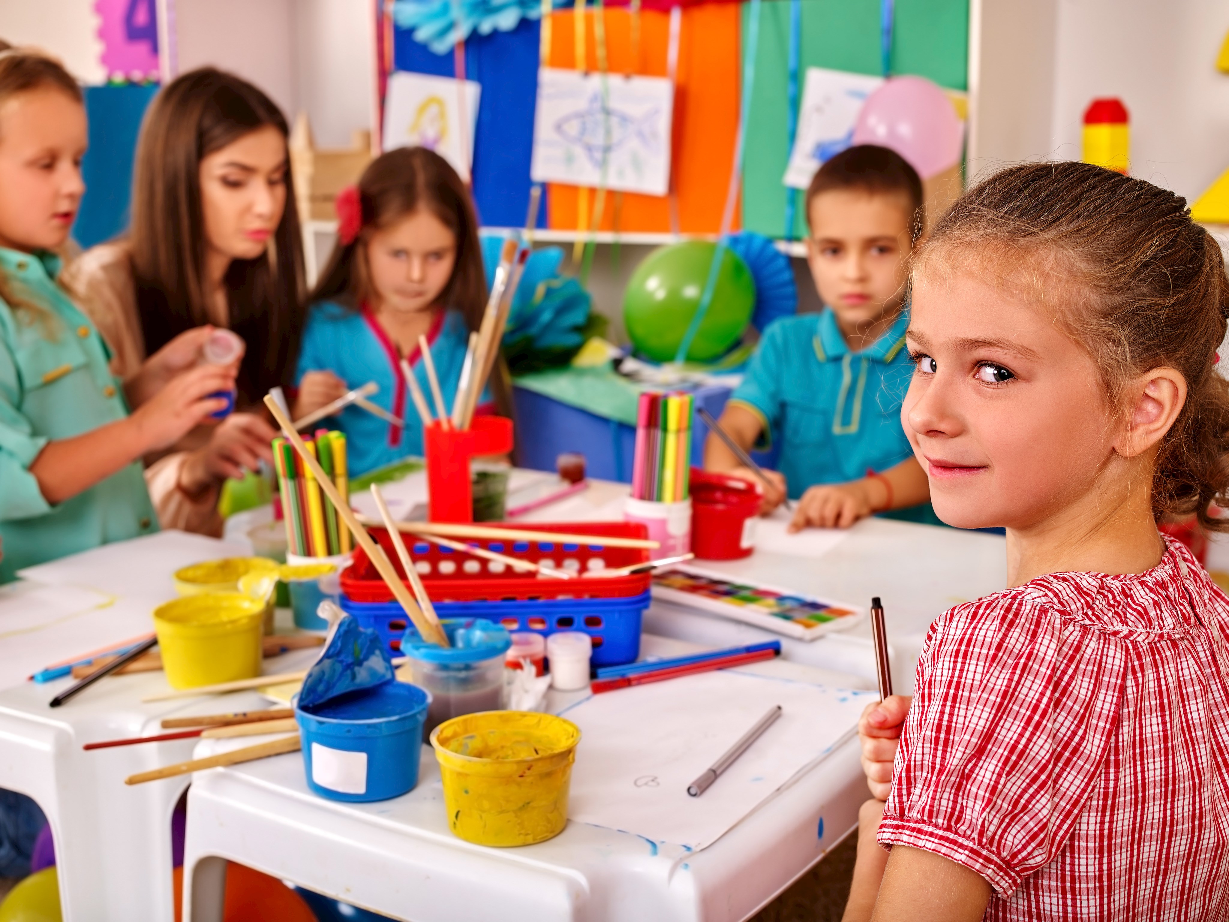 Kinder mit Erzieherin beim Basteln