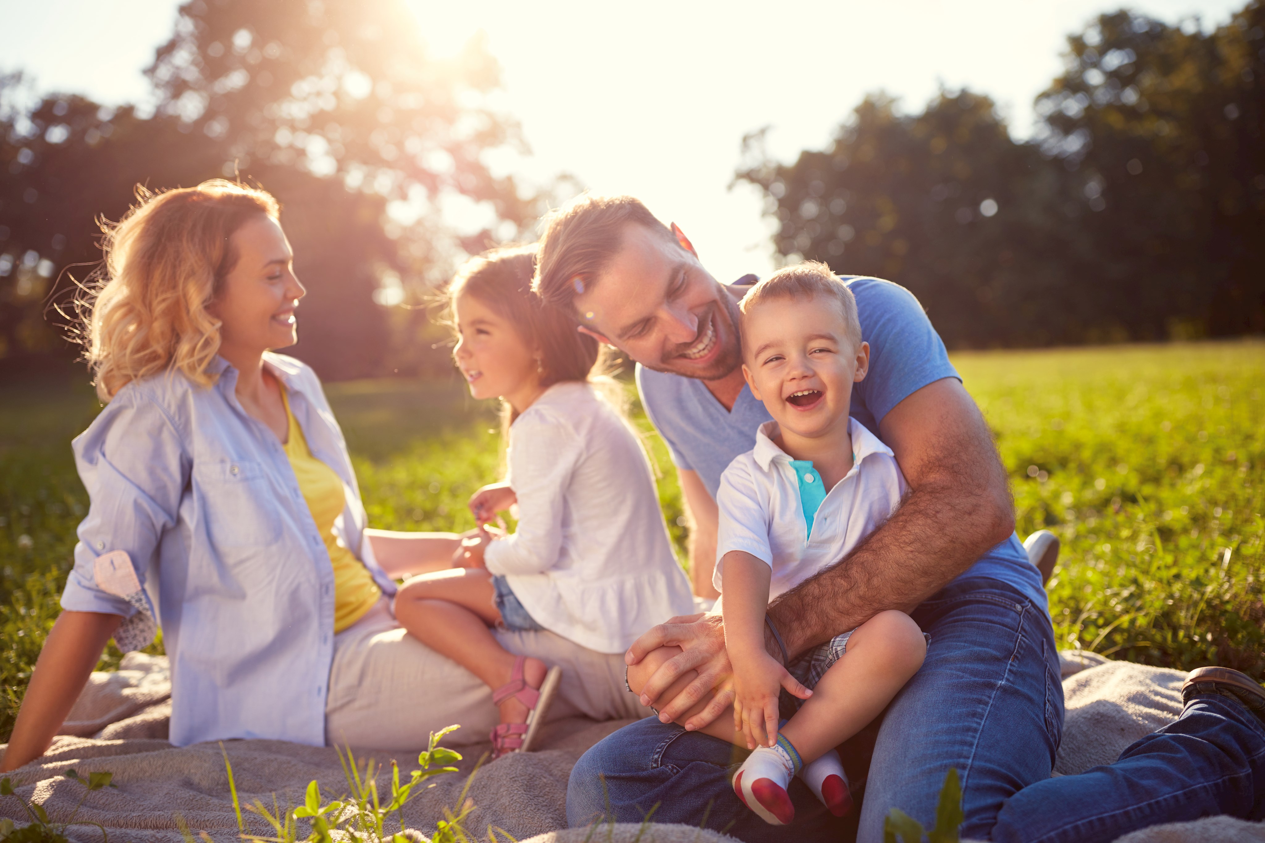 Familie sitzt freudig im Gras
